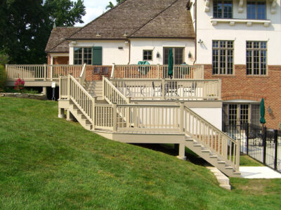 Deck Builder Brentwood, MO Khaki Vekadek decking on a white and brick home